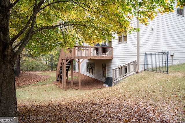 rear view of property with a wooden deck and a yard