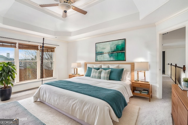 bedroom featuring light carpet, a tray ceiling, ornamental molding, and ceiling fan