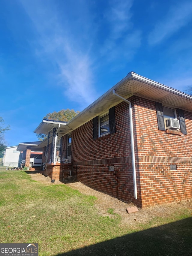 view of side of property with a lawn and cooling unit