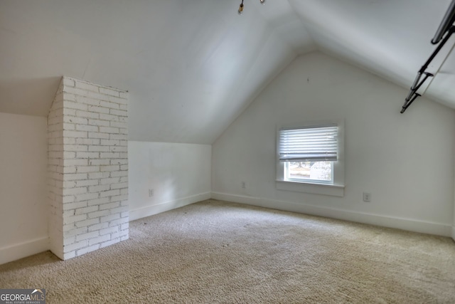 bonus room with light colored carpet and lofted ceiling