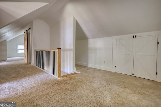 bonus room with light colored carpet and lofted ceiling