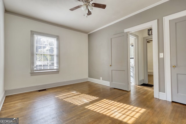 spare room featuring crown molding, hardwood / wood-style floors, and ceiling fan