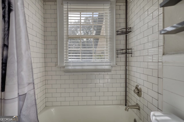 bathroom with shower / bath combo with shower curtain and a wealth of natural light