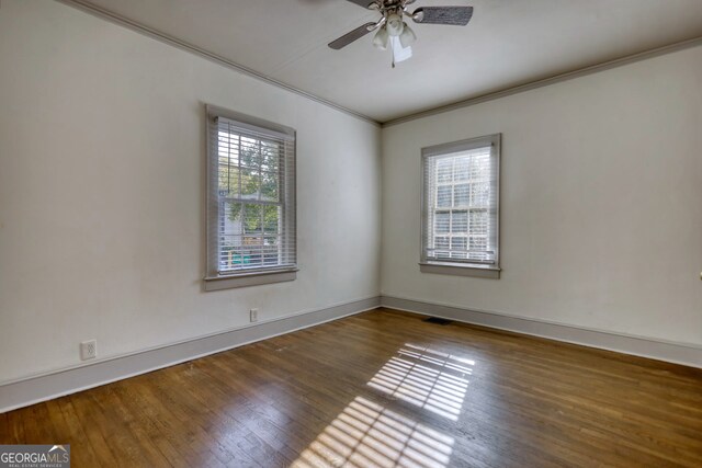 spare room with plenty of natural light, ceiling fan, dark hardwood / wood-style flooring, and crown molding