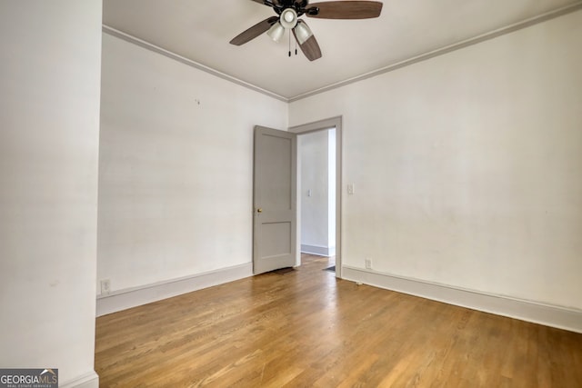 empty room featuring ceiling fan, wood-type flooring, and ornamental molding