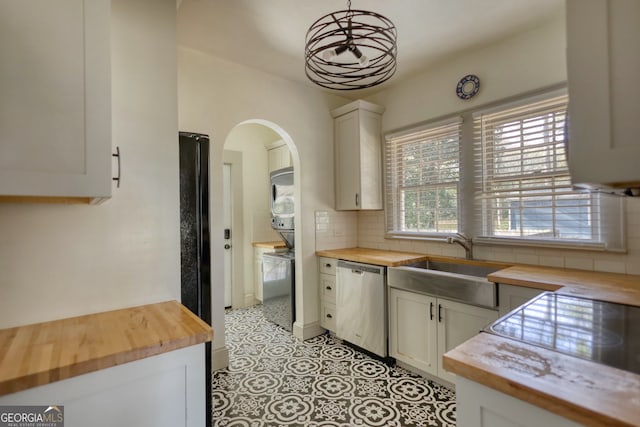 kitchen featuring white cabinets, butcher block countertops, stainless steel dishwasher, and sink