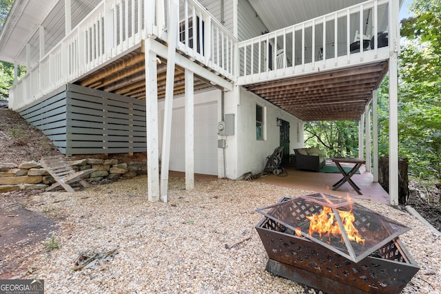 view of side of home featuring a fire pit, a garage, and a wooden deck