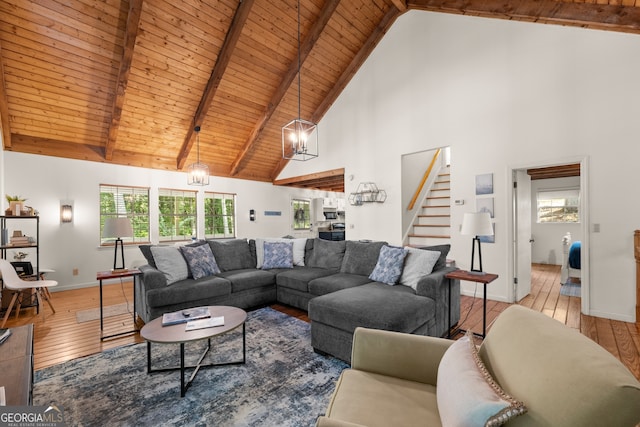 living room featuring a notable chandelier, light hardwood / wood-style floors, wooden ceiling, and high vaulted ceiling