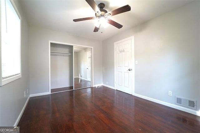 unfurnished bedroom featuring a closet, dark hardwood / wood-style floors, and ceiling fan