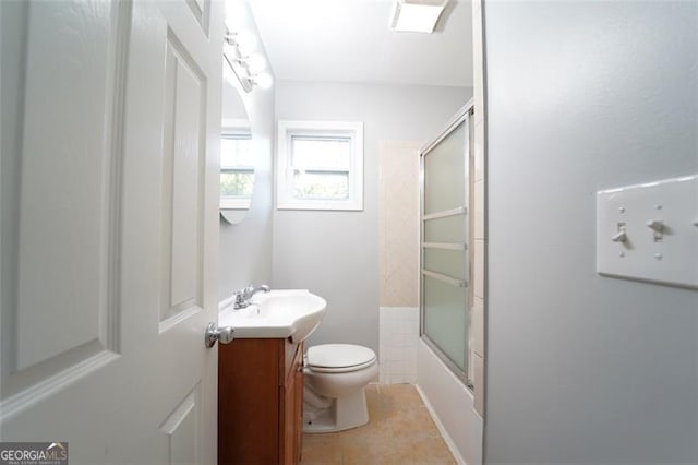 full bathroom featuring tile patterned floors, shower / bath combination with glass door, vanity, and toilet