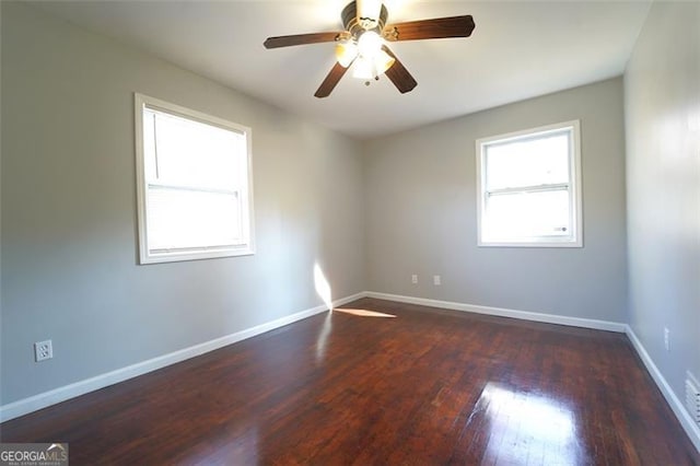 empty room with ceiling fan and dark hardwood / wood-style flooring