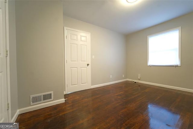 spare room with dark wood-type flooring