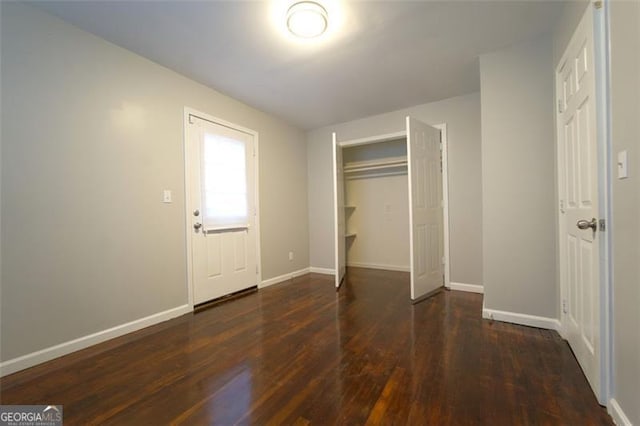 unfurnished bedroom featuring dark hardwood / wood-style floors and a closet