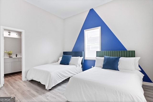 bedroom featuring light hardwood / wood-style floors and ensuite bathroom