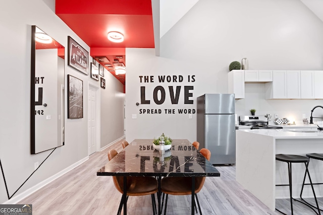 kitchen featuring appliances with stainless steel finishes, light hardwood / wood-style flooring, white cabinetry, and sink