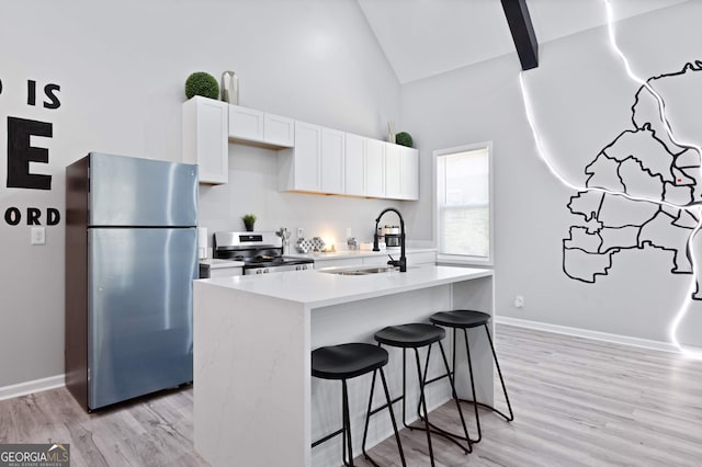 kitchen featuring a center island with sink, white cabinets, sink, light hardwood / wood-style flooring, and appliances with stainless steel finishes