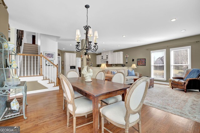 dining area featuring light hardwood / wood-style flooring and an inviting chandelier