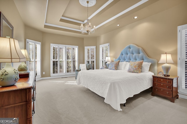 carpeted bedroom with a tray ceiling and an inviting chandelier