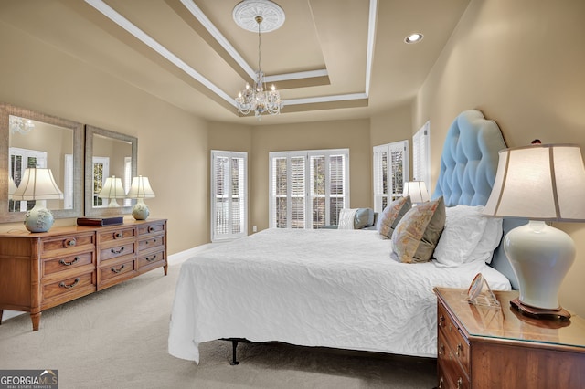 carpeted bedroom featuring a chandelier and a raised ceiling