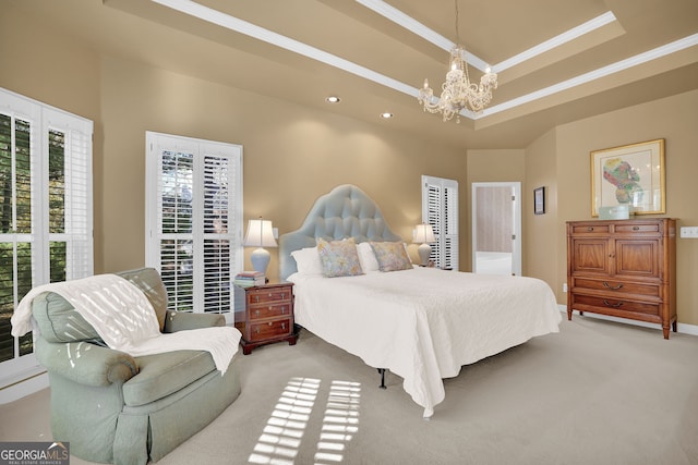 carpeted bedroom featuring a tray ceiling and a notable chandelier