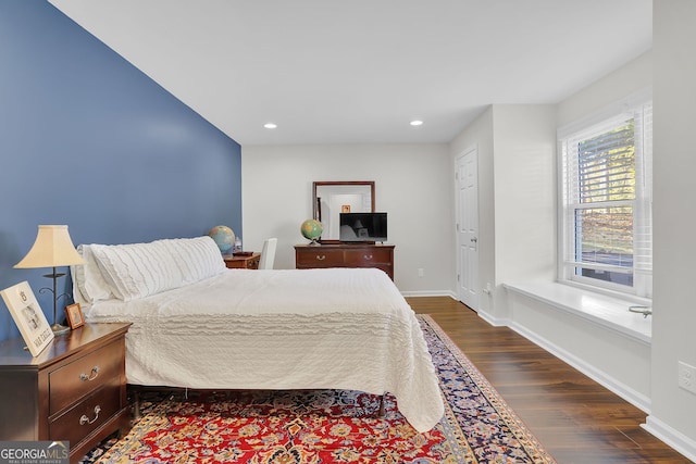 bedroom with dark hardwood / wood-style floors