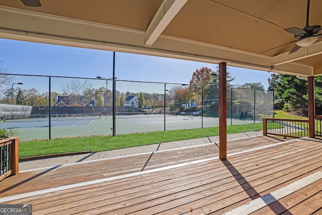 wooden deck with ceiling fan and tennis court