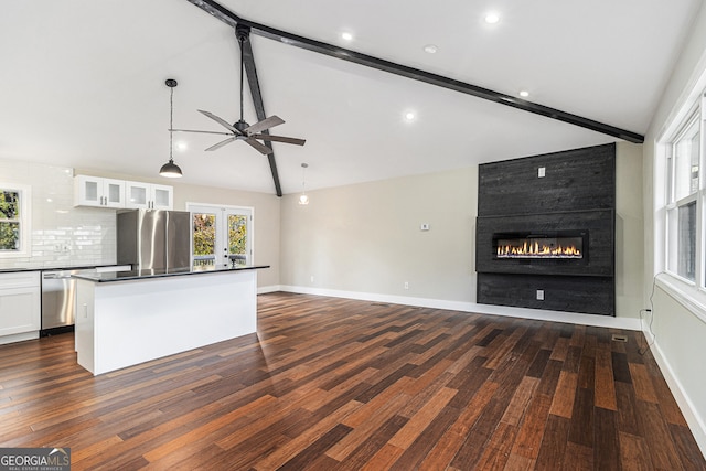 kitchen with lofted ceiling with beams, a fireplace, white cabinetry, and stainless steel appliances