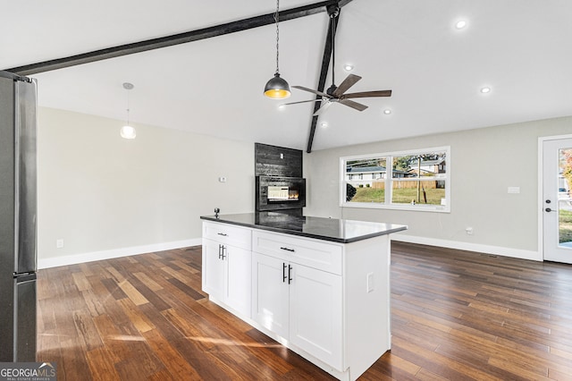 kitchen with lofted ceiling with beams, white cabinetry, ceiling fan, and hanging light fixtures