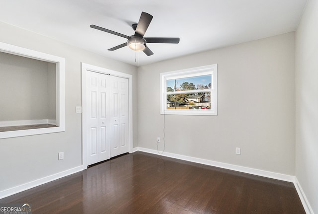 unfurnished bedroom featuring a closet, dark hardwood / wood-style floors, and ceiling fan