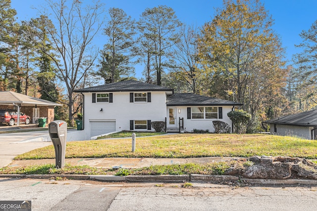 tri-level home featuring a front lawn and a garage