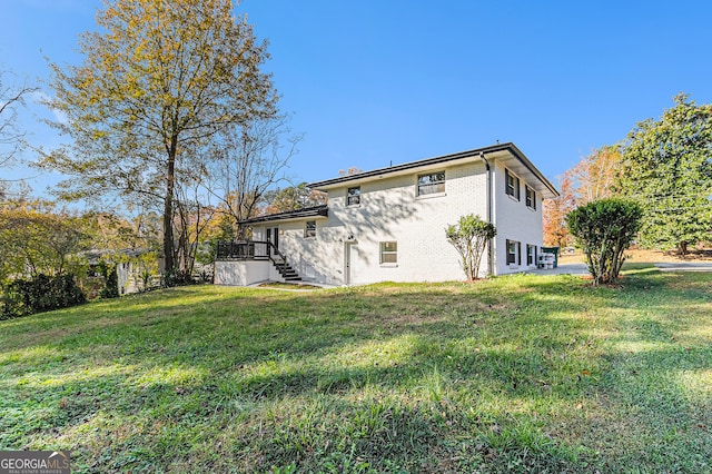 rear view of house with a yard and a deck