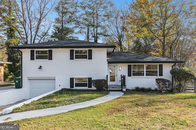 tri-level home with a garage and a front yard