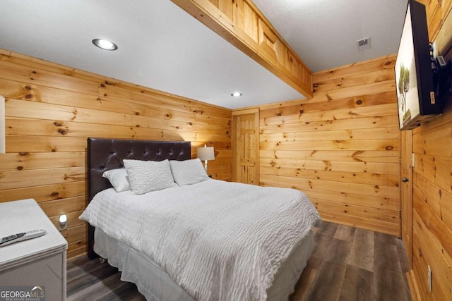 bedroom featuring dark hardwood / wood-style flooring and wooden walls