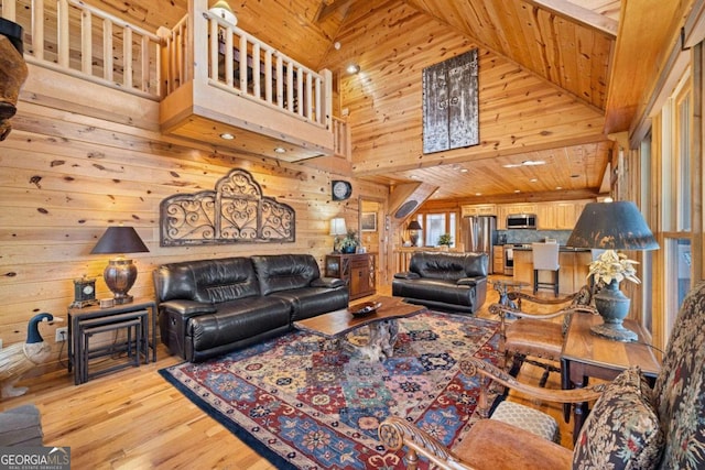 living room with wood walls, wood ceiling, high vaulted ceiling, and light hardwood / wood-style flooring