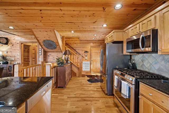 kitchen featuring stainless steel appliances, wooden ceiling, light hardwood / wood-style flooring, wood walls, and dark stone counters