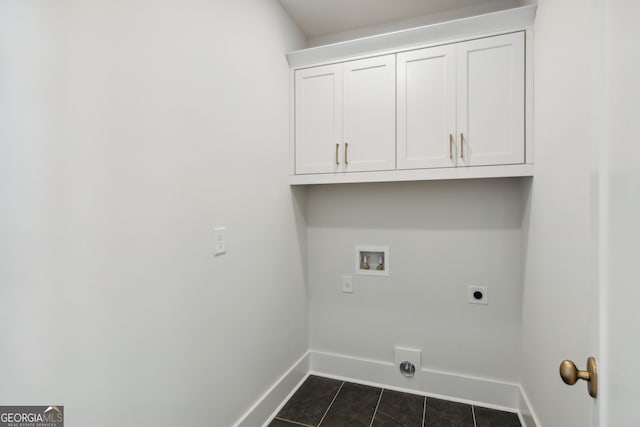 washroom featuring hookup for a washing machine, electric dryer hookup, dark tile patterned flooring, and cabinets