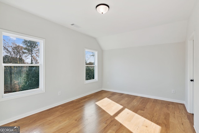 bonus room with vaulted ceiling and light hardwood / wood-style flooring