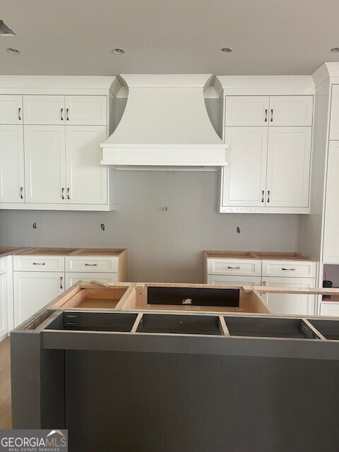 kitchen featuring custom exhaust hood and white cabinets