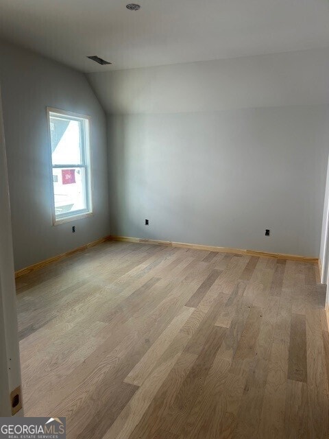 additional living space with lofted ceiling and light wood-type flooring