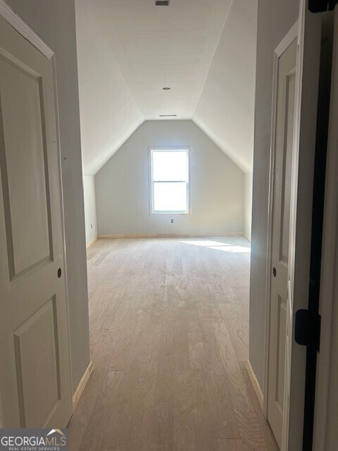 bonus room featuring lofted ceiling and light hardwood / wood-style flooring