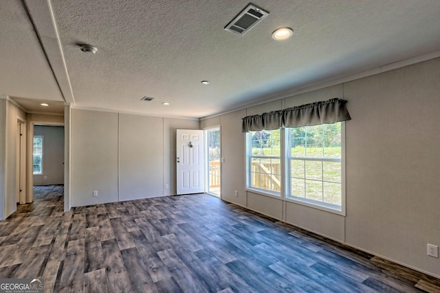 empty room featuring ornamental molding, dark hardwood / wood-style floors, and a textured ceiling