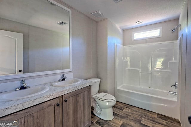 full bathroom featuring shower / bath combination, vanity, hardwood / wood-style floors, and toilet