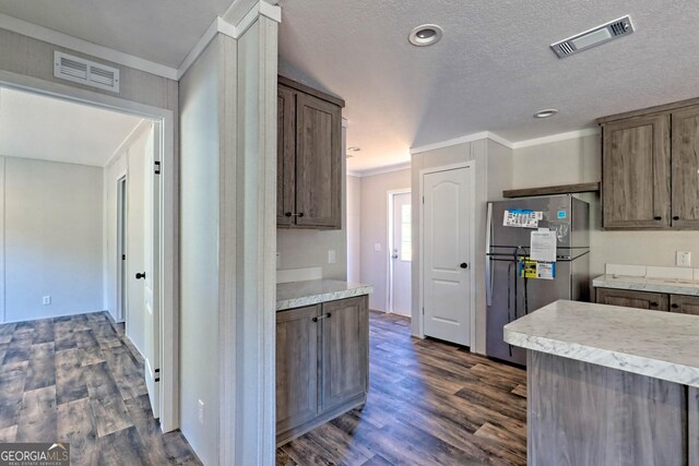 kitchen featuring appliances with stainless steel finishes, dark hardwood / wood-style flooring, sink, a center island with sink, and decorative light fixtures