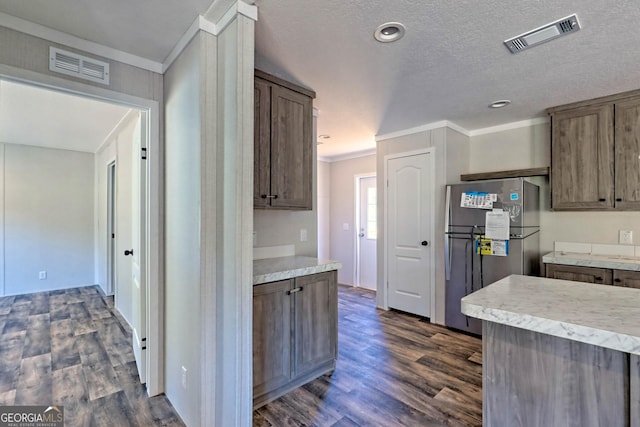 kitchen with crown molding, stainless steel fridge, dark hardwood / wood-style floors, and a textured ceiling