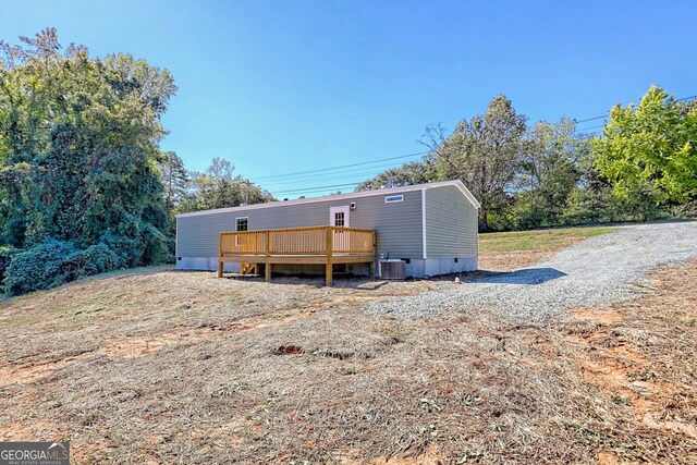 rear view of property featuring a deck and central AC unit