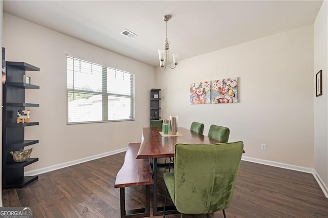 dining room featuring dark hardwood / wood-style flooring and an inviting chandelier