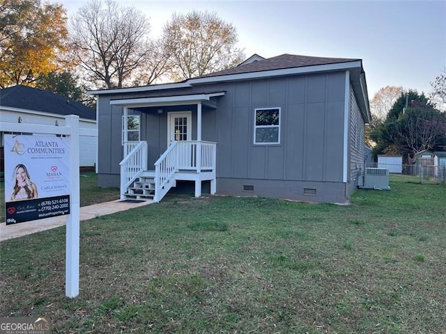 view of front of home with cooling unit and a front lawn