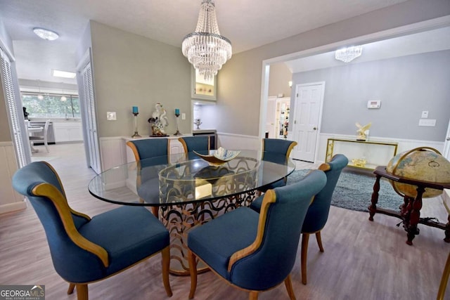 dining space featuring light hardwood / wood-style floors and an inviting chandelier