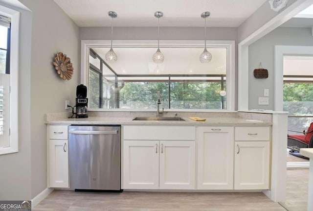 kitchen featuring dishwasher, white cabinets, and a healthy amount of sunlight