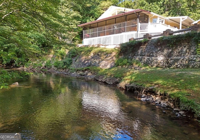 exterior space featuring a water view and a sunroom